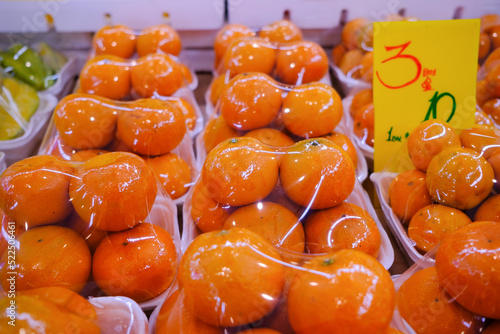 Принти на полотні Fresh oranges at market stall display wrapped with plastic film wrap for protection of the fruits