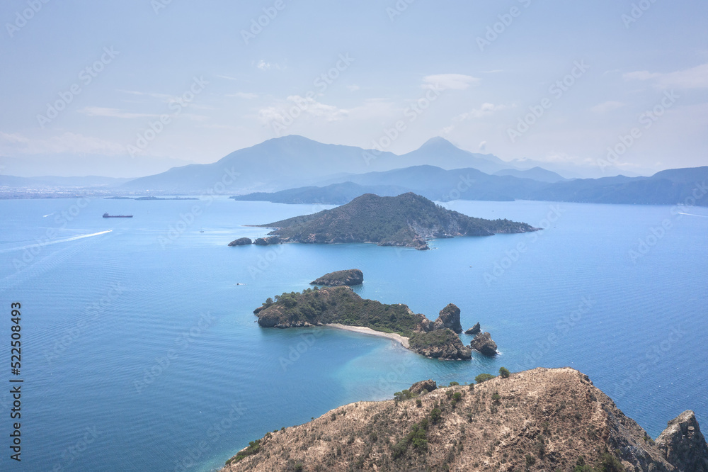 Beautiful aerial view of scope the sea and mountains in the morning. Small rocky islands in sea close to Fethiye. Some ships in the sea and between islands.