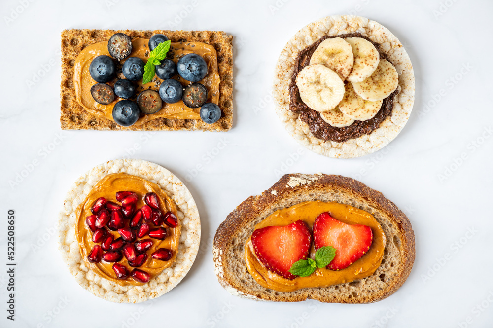Various kind of open sandwiches with berries and fruits. Made from bread, such as wholegrain, rice crakers, crispbreads and different nut butter, such as peanut, crunchy cashew and almond butter Various kind of open sandwiches with berries and fruits. Made from bread, such as wholegrain, rice crakers, crispbreads and different nut butter, such as peanut, crunchy cashew and almond butter