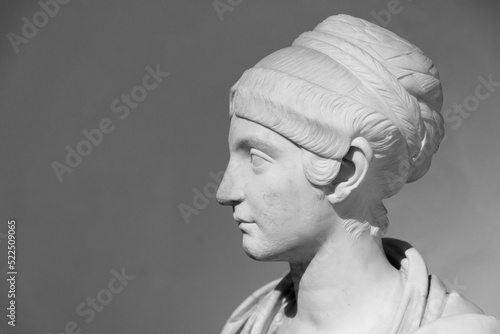 Black and white photo in close-up on ancient roman statue portraiting the profile of a woman
