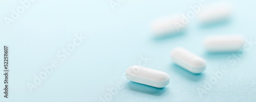White pills isolated on blue background