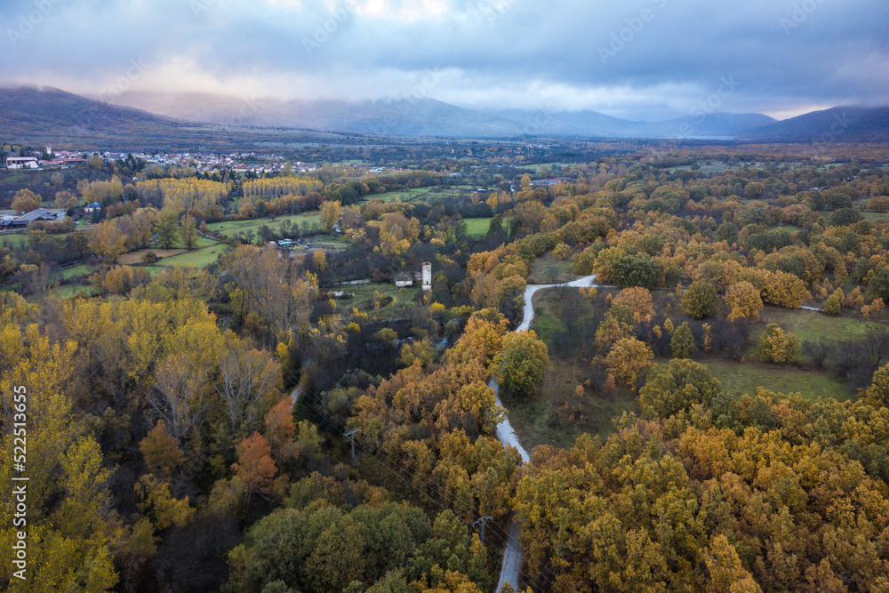 Scenic autumn landscape with lush green trees and small settlement in highlands Scenic autumn landscape with lush green trees and small settlement in highlands