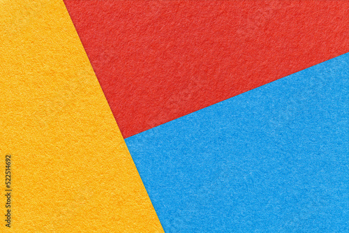Texture of craft yellow, blue and bright red shade color paper background, macro. Abstract cardboard