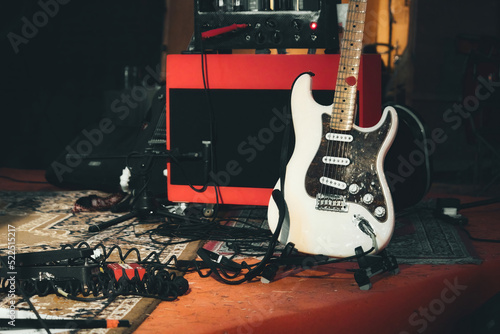 Stampa su tela A white electric guitar and a red amplifier onstage with electrical audio cables