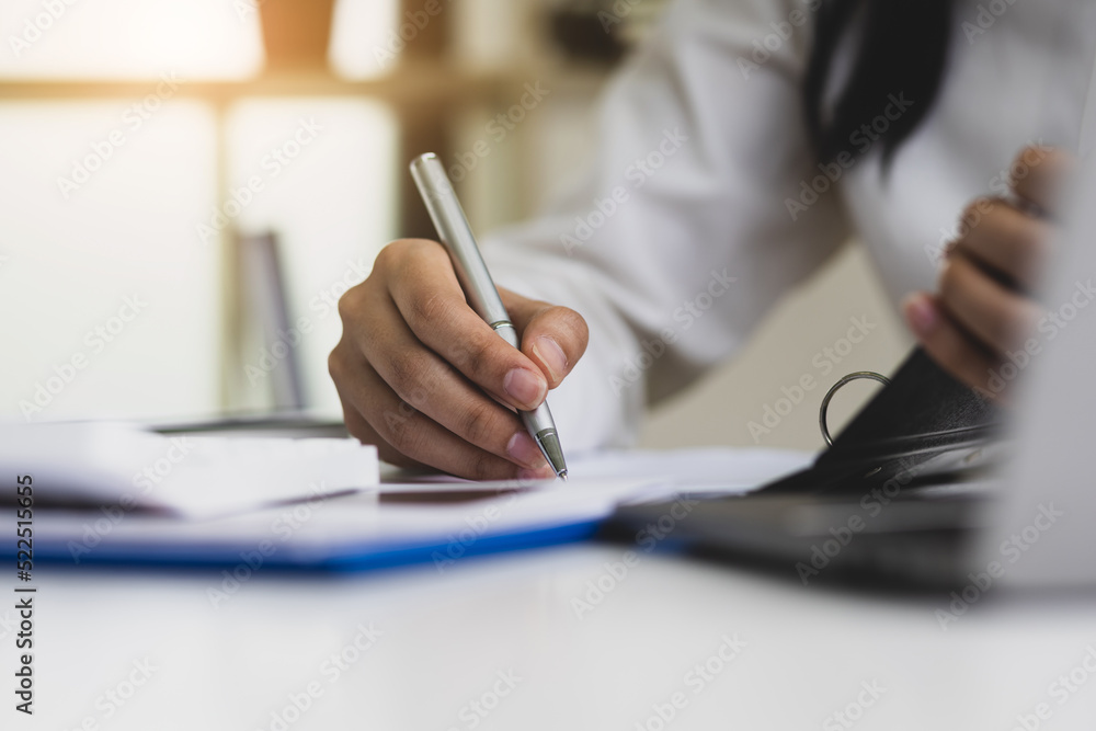 The secretary is writing the memo of the working message in the file. The secretary is writing the memo of the working message in the file.