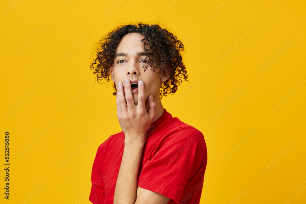 Shocked confused funny Caucasian young man in red t-shirt touches cheeks posing isolated on over yellow studio background. The best offer with free place for advertising. Emotions for everyday concept Shocked confused funny Caucasian young man in red t-shirt touches cheeks posing isolated on over yellow studio background. The best offer with free place for advertising. Emotions for everyday concept