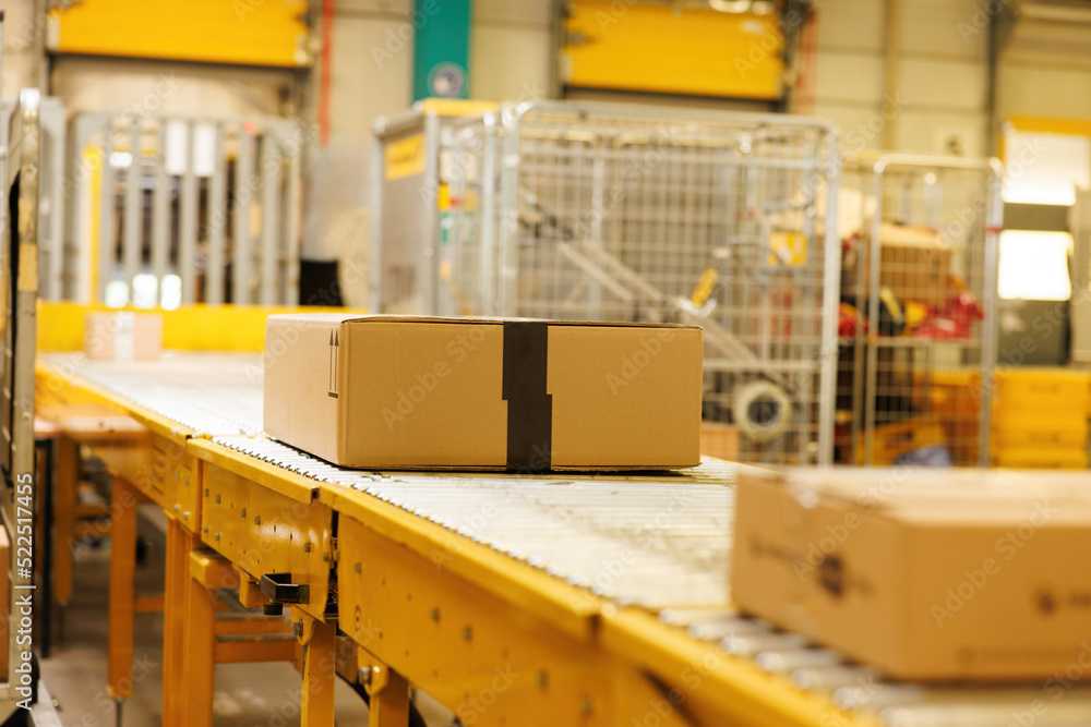 Box on conveyor roller. Delivery service, distribution warehouse and parcels transportation system.