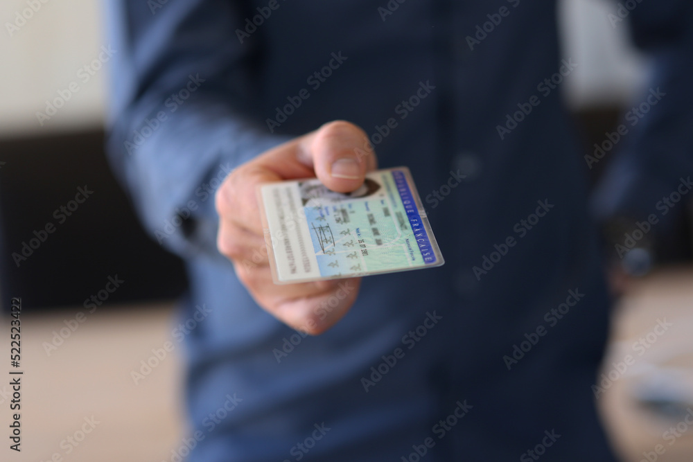 Man giving us his identity card - French identity card Man giving us his identity card - French identity card