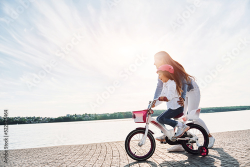 Majestic view of the lake. Mother with her young daughter is with bicycle outdoors together