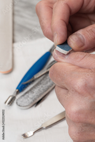 Obraz na plátně A woman makes herself a manicure, polishes, smoothers her nails with an emery file for nails, takes care of her nails