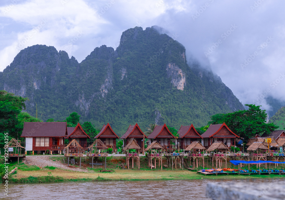 Fototapeta premium Vang Vieng Laos a beautiful city on the river with huge rising mountains and slow flowing river. 