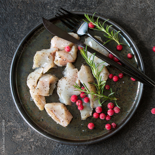 whitefish appetizer with berries and rosemary on the table photo