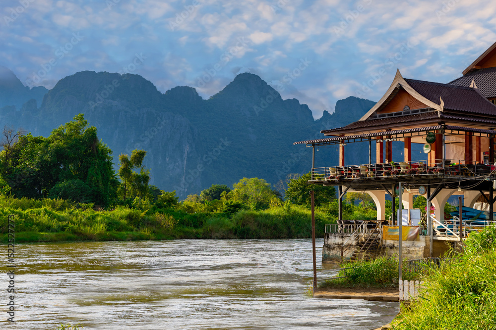 Obraz premium Vang Vieng Laos a beautiful city on the river with huge rising mountains and slow flowing river.