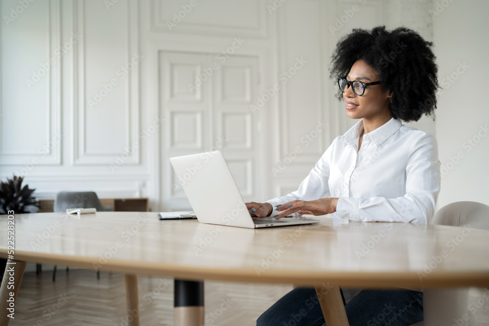 A business woman works in an office in formal clothes, uses a laptop A business woman works in an office in formal clothes, uses a laptop