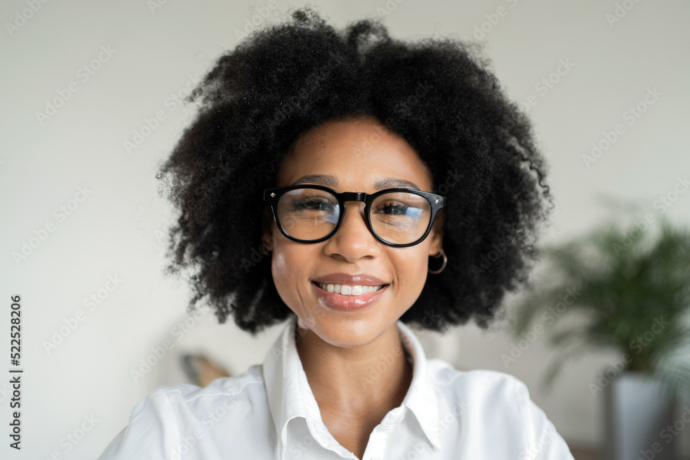 Portrait of a business woman smiling showing her teeth in the office with glasses looking at the camera Portrait of a business woman smiling showing her teeth in the office with glasses looking at the camera