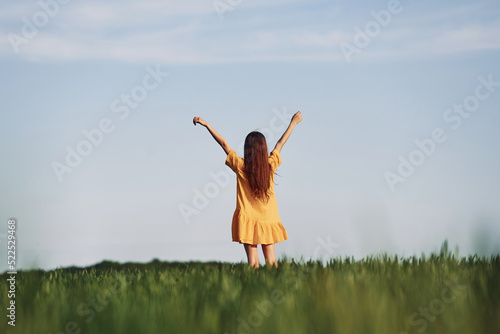 Hands raised up. Enjoying nature. Happy girl have a walk outdoors on the field at summer