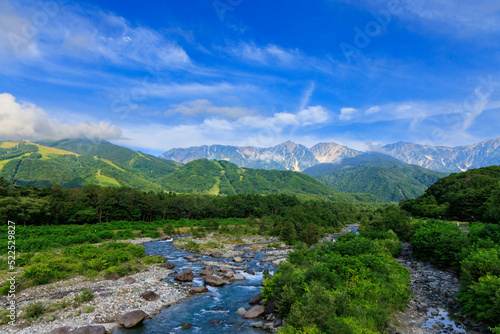 夏の美しい白馬村の松川から見える五竜岳と雪渓
