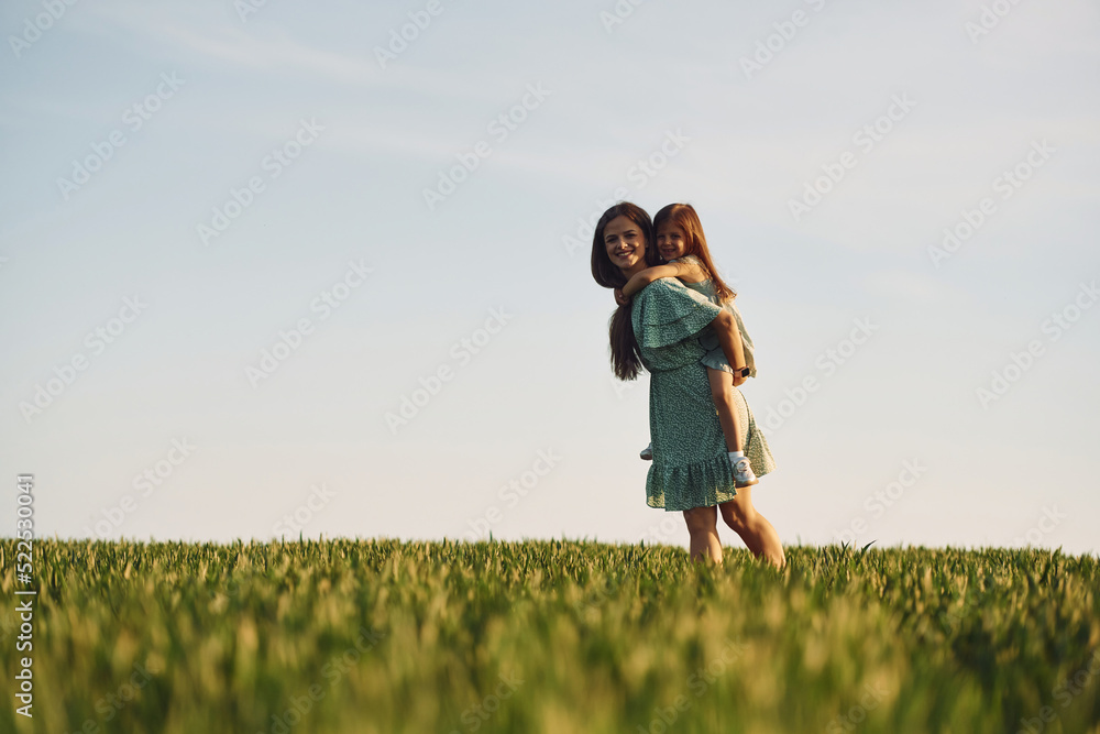 Clear sky. Mother and daughter have fun outdoors on the field at summer Clear sky. Mother and daughter have fun outdoors on the field at summer
