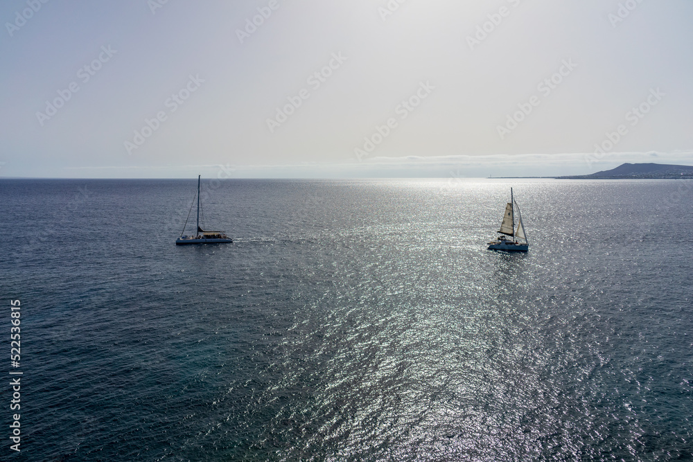 Seascape with sun reflection. Pleasure yachts in the sea.
