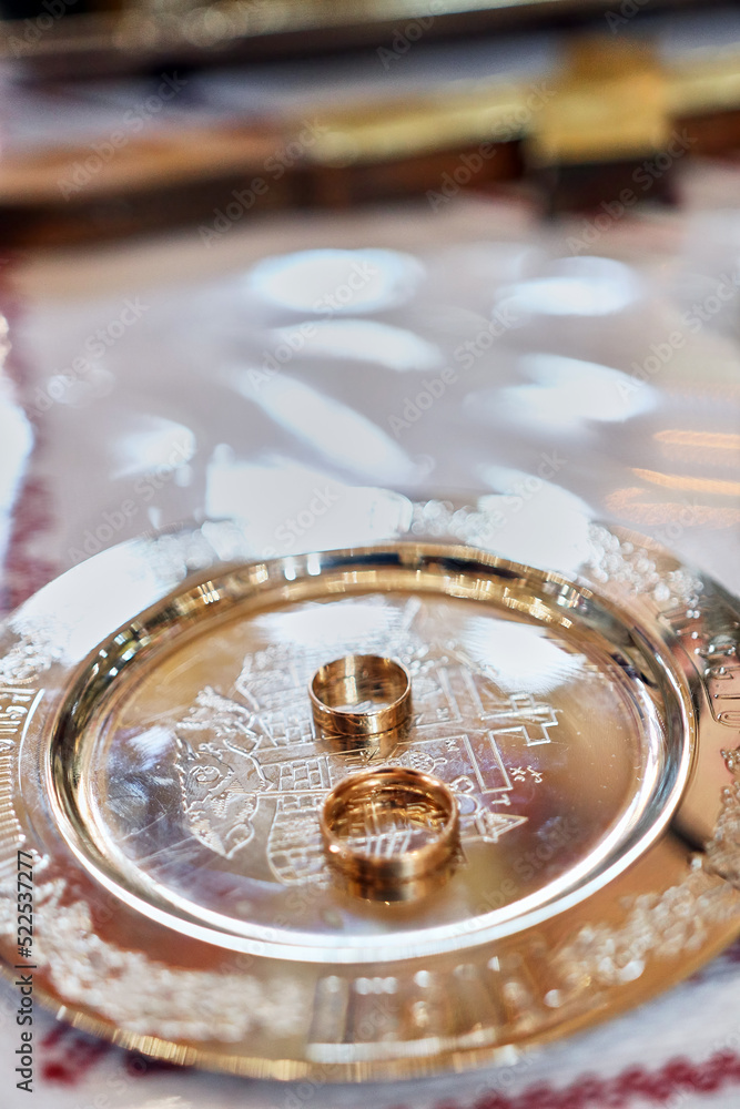 During a church wedding, gold wedding rings lie on the church slab. During a church wedding, gold wedding rings lie on the church slab.
