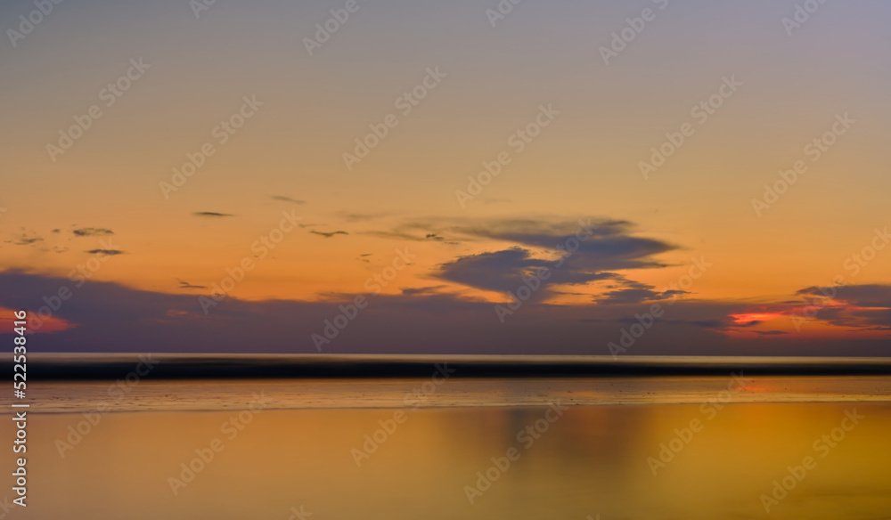 Golden sunset in the sea. Background or screensaver idea. Image has grain or blur, noise, and blurry focus when viewed at full resolution. (Shallow depth of field, slight motion blur)