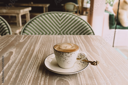 Fototapeta Naklejka Na Ścianę i Meble -  white cup of hot cappuccino on wooden light table background.