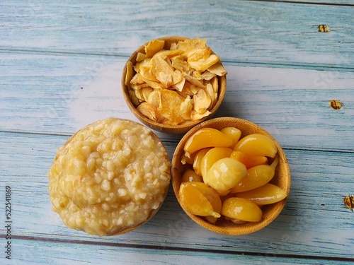 Thinly sliced ​​fried garlic in a wooden bowl ,isolated on a wooden table, top view, space for text. A great ally of health. photo