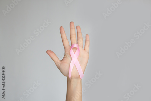 Pink bow ribbon in human hand to encourage breast cancer patient. Breast cancer campaign in October month