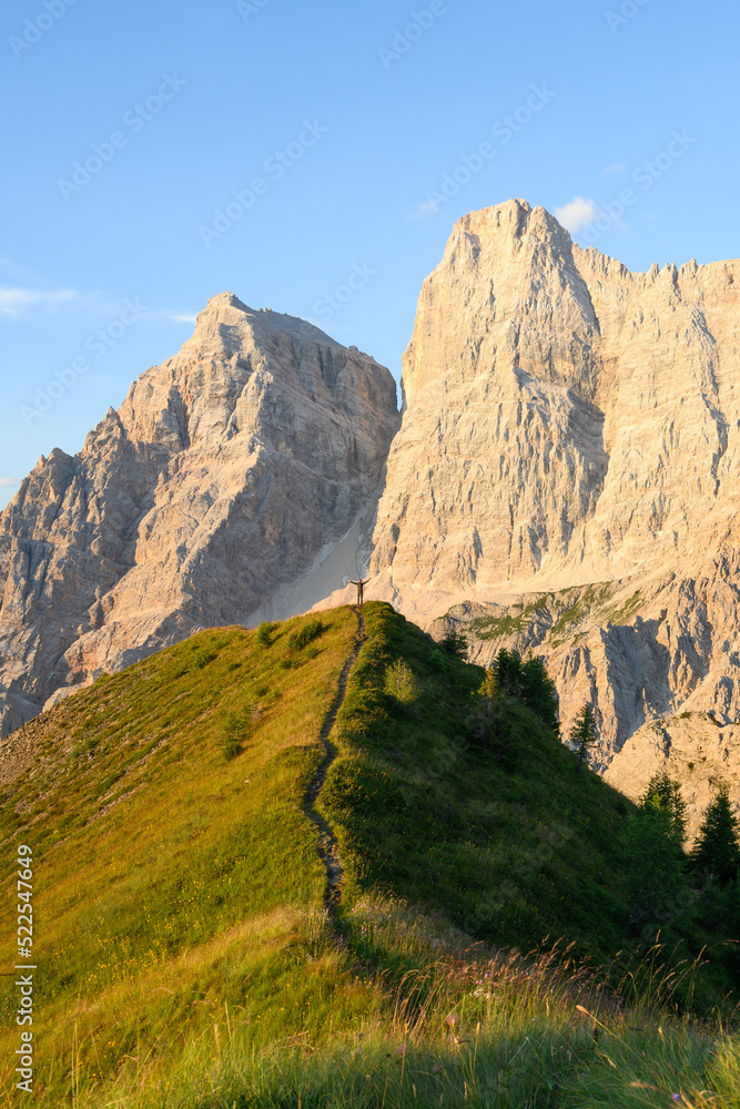 Stunning view of a person enjoying the view of Monte Pelmo from the summit of Col de la Puina. Monte Pelmo was the very first high mountain of the Dolomites that was climbed, Italy