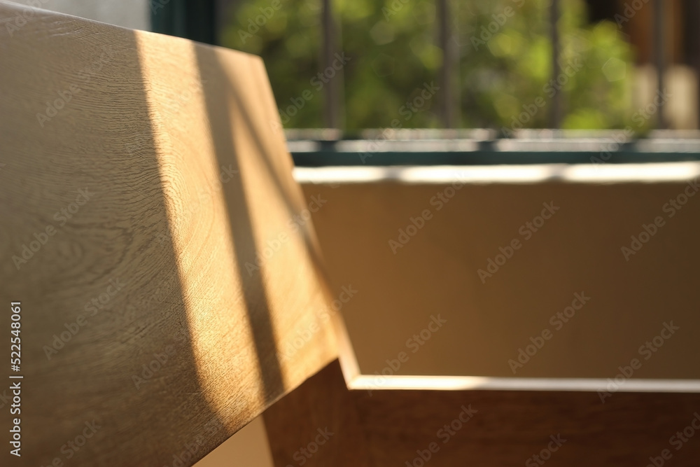 A chair modern wood frame with wooden, sunlight coming through the window illuminating the chair A chair modern wood frame with wooden, sunlight coming through the window illuminating the chair