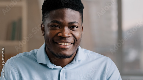 Portrait of successful handsome African American businessman male 30s ethnic boss ceo freelancer customer brunet adult man guy dreaming turns head looking at camera smiling toothy white healthy smile