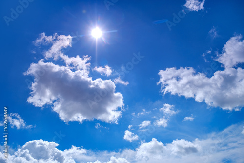 Blue sky background with sunny summer clouds