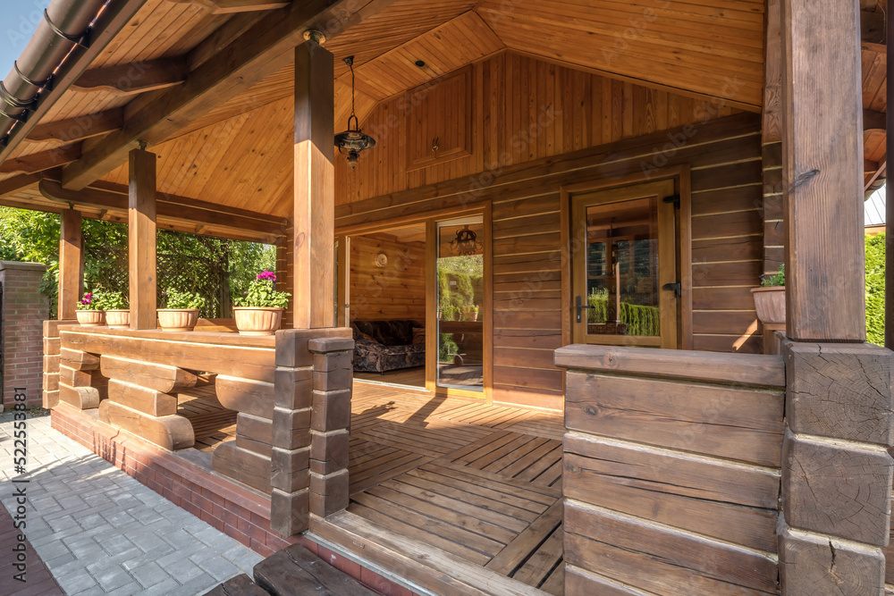 interior of empty hall veranda in wooden village vacation home with garden chairs