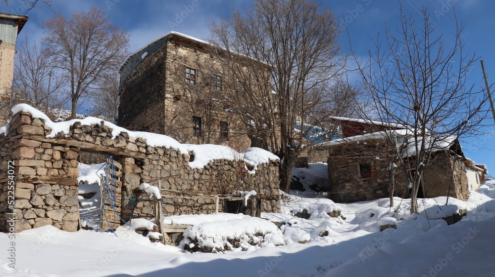 Man made stone houses at winter time with some snow around them