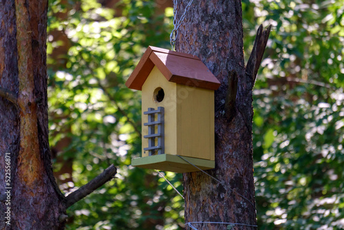 Birdhouse or bird box with natural green leaves background. Selective focus