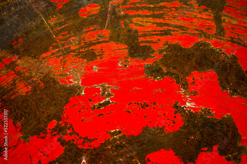 Rusty and dirty metal surface with old red paint.