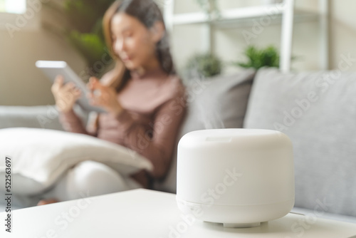 Foto Air Humidifier Device At home and Woman relaxing on the sofa