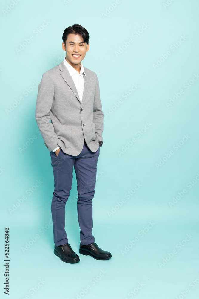 Portrait of young Asian businessman standing isolated on green background, Full body composition Portrait of young Asian businessman standing isolated on green background, Full body composition