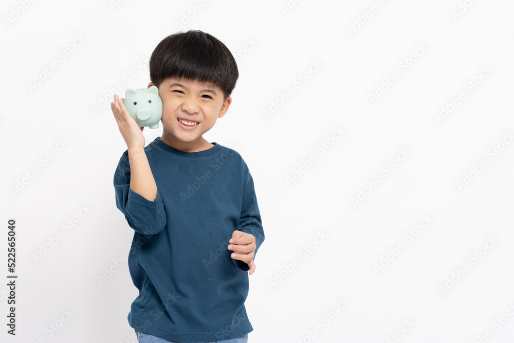 Portrait of happy Asian little boy holding sky blue piggy bank isolated on white background, Saving money and financial economize concept Portrait of happy Asian little boy holding sky blue piggy bank isolated on white background, Saving money and financial economize concept