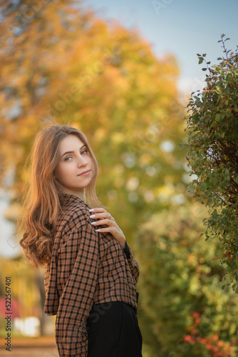 Portrait of a young beautiful girl on an autumn day in the park. There is artistic noise.