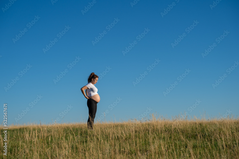 Pregnant woman walking in nature Pregnant woman walking in nature