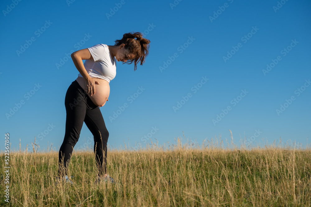 Pregnant woman walking in nature Pregnant woman walking in nature