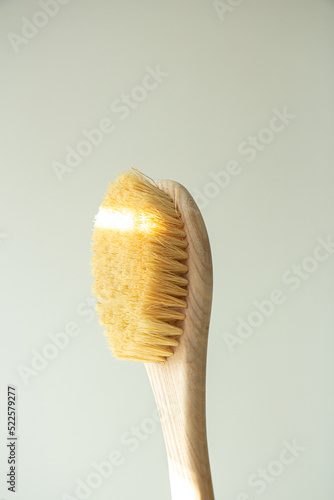 Dry natural bristle brush with wooden handle for anti cellulite massage. Close-up of massage brush for skin