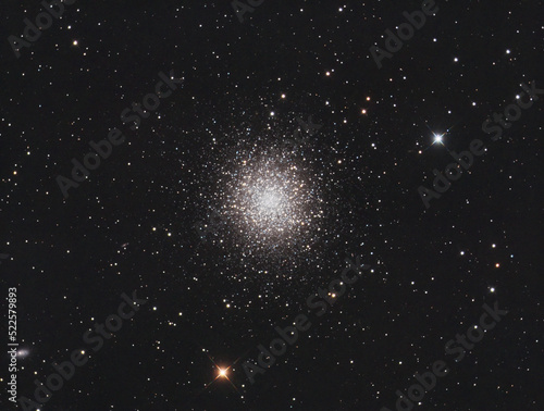 Messier 13 globular cluster in Hercules constellation, with many stars as background and a galaxy on the left.
