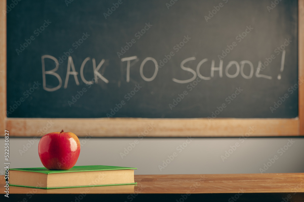 Apple on a book on blackboard background. Education concept Apple on a book on blackboard background. Education concept