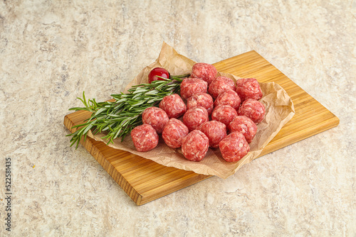 Raw uncooked beef meatballs served rosemary