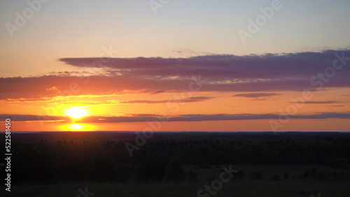 Rural landscape. A beautiful sunset on a hill and a forest stretching to the horizon. Leningrad region, Russia. photo