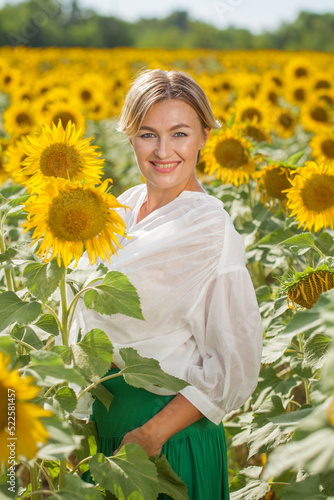 Happy beautiful blonde woman in sunflowers field