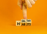 Healthy habits symbol. Concept words Healthy habits on wooden cubes. Doctor hand. Beautiful orange table orange background. Medical and healthy habits concept. Copy space.