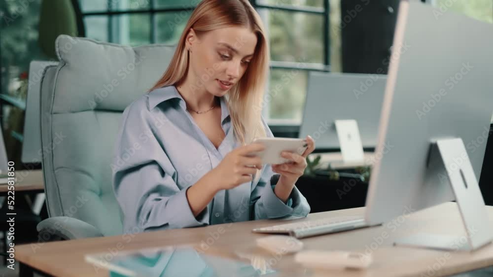 Lazy bored office worker playing mobile games in office during boring work day. Relaxation and job concept. Lazy bored office worker playing mobile games in office during boring work day. Relaxation and job concept.
